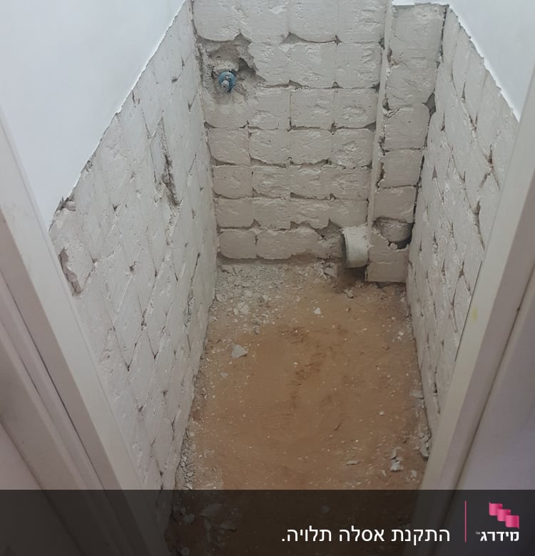 קיר לבנים חשוף עם צינור מים בולט